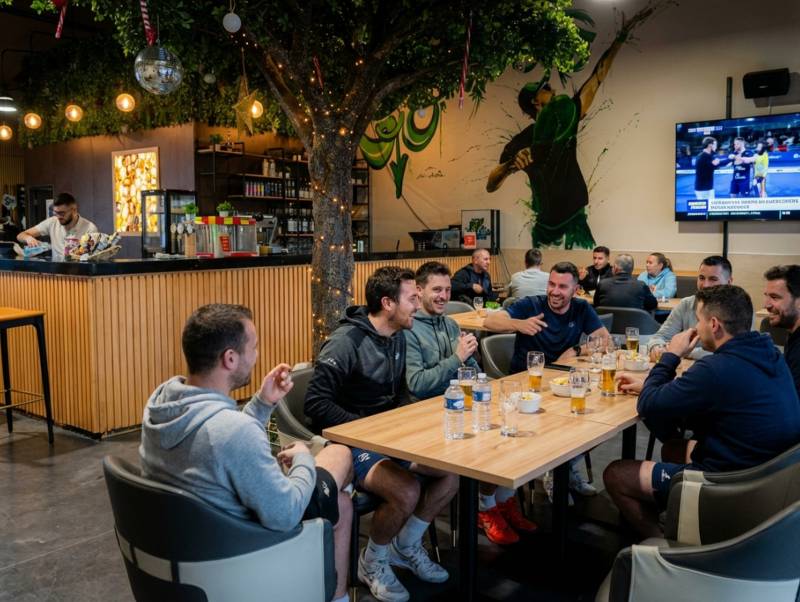 Ambiance conviviale après-match d'entreprise au bar du complexe de padel Univers Padel